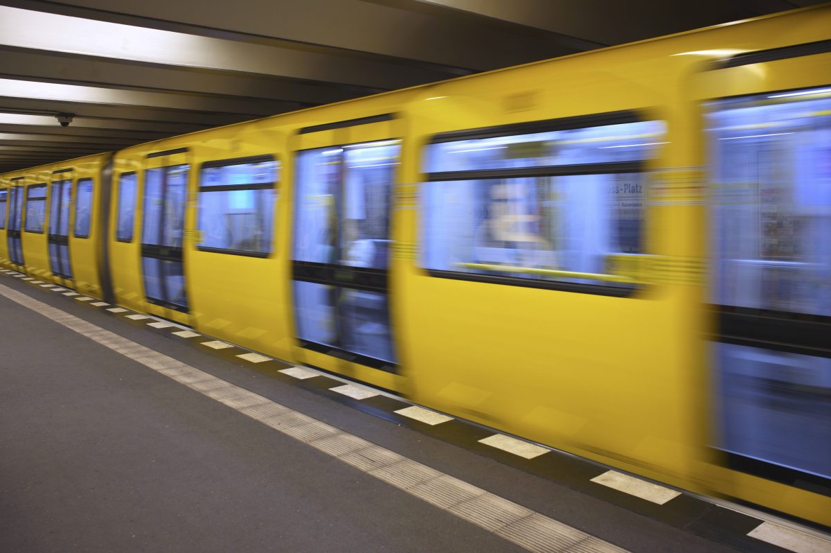 Eine Berliner U-Bahn fährt an einem Bahnhof ein.